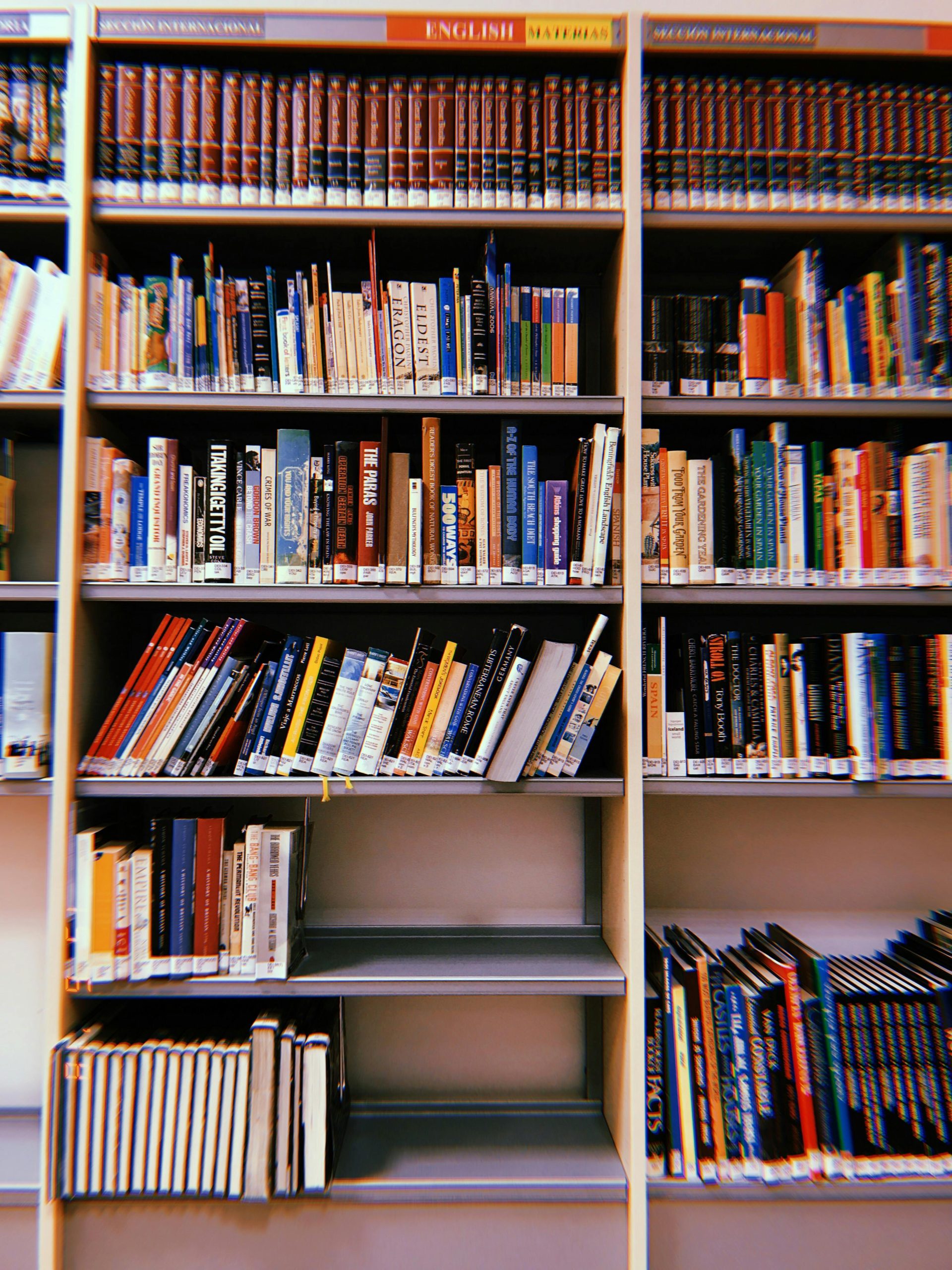 Vibrant photo of a library bookshelf in Madrid, showcasing diverse book genres and colorful covers.